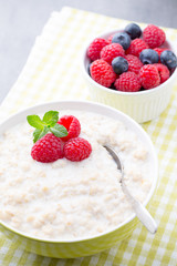 Oatmeal porridge in bowl with berries raspberries and blackberri