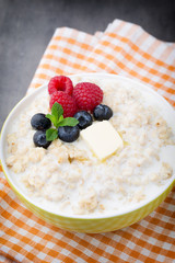Oatmeal porridge in bowl with berries raspberries and blackberri