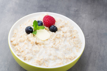 Oatmeal porridge in bowl with berries raspberries and blackberri