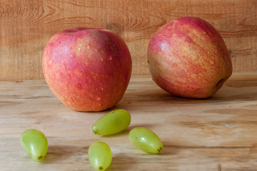 Closed up new and fresh apple and grapes on wood background