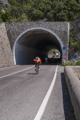 Cyclists enter a tunnel Capo d'Orso, Amalfi coast, Italy