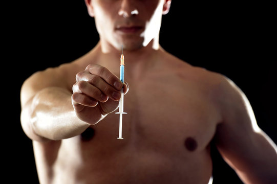 Young Athletic Sportsman Holding Syringe In Sport Doping And Cheat Concept