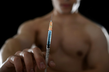 young athletic sportsman holding syringe in sport doping and cheat concept - obrazy, fototapety, plakaty