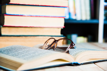 book and glasses on table in library