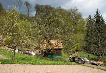 Fototapeta premium Tractor on Gield with Small farm House