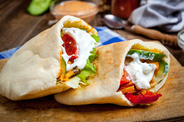 Fried chicken meat with vegetables in pita bread