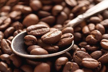 Macro shot of coffee beans in vintage silver spoon