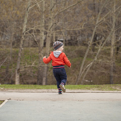 The three-year young boy walking in the spring park