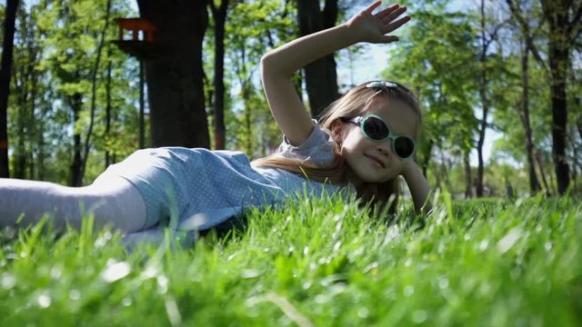Beauty Girl lying on the Meadow with green grass