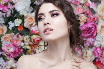 Obraz na płótnie Canvas Portrait of beautiful fashion girl, sweet, sensual. Beautiful makeup and messy romantic hairstyle. Flowers background. Green eyes. 
