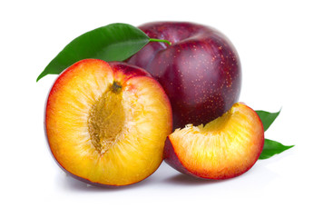 Ripe purple plum fruits with green leaves isolated