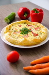 Homemade Spinach and Bacon Egg Quiche in a pie crust on wood board. French cuisine