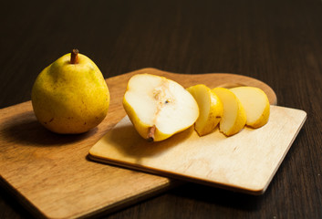 the cut, yellow pears on a wooden, dark background