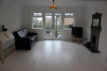 A Contemporary living area being decorated with white walls and floorboards