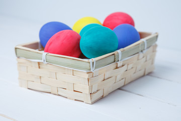 Easter, holidays, tradition and object concept - close up of colored easter eggs in basket