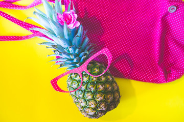 fashion pineapple with polka dot glasses and bag on yellow background