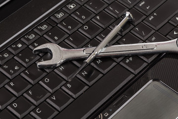 Fototapeta premium wrench tool and screwdrivers over a laptop