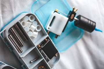 Tattoo artist preparing for work, details to tattoo machine and capsules for paints