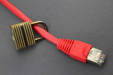 Red ethernet cable with padlock on a grey paper background signifying network security