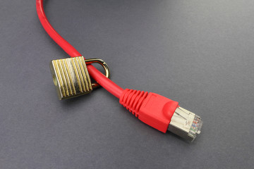 Red ethernet cable with padlock on a grey paper background signifying network security