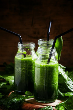 Green detox drink, a glass bottle, a vintage wooden background,