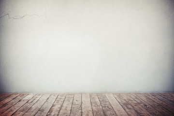 Grey wall with cracks and natural brown wooden floor
