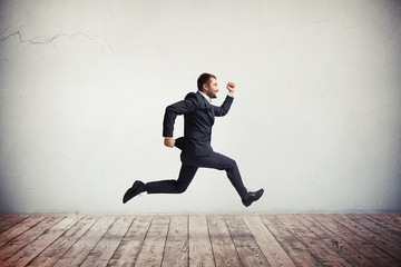 Man in formal wear running and jumping with happy smile