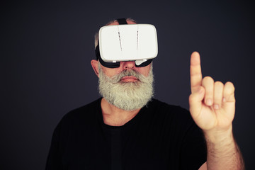 Fototapeta premium Senior man touch something using virtual reality glasses