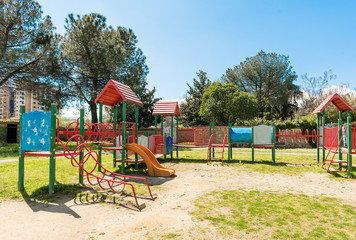 Fototapeta na wymiar Colorful playground for kids inside a urban public park, Italy