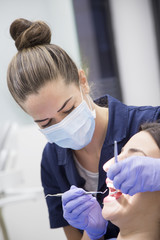 Naklejka premium At the dentist. Female dentist in action