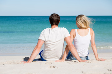 Romantic young couple sitting on the beach