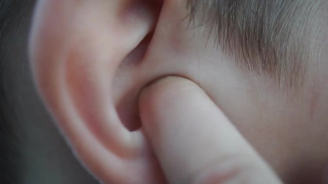 Boy picking his ear close up