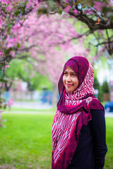 A muslim women with sakura trees as background