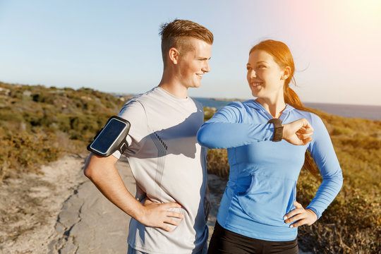 Runner woman with heart rate monitor running on beach - Powered by Adobe