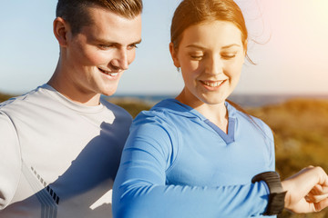 Runner woman with heart rate monitor running on beach