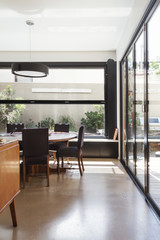 Modern dining room with concrete floor and glass bi fold doors