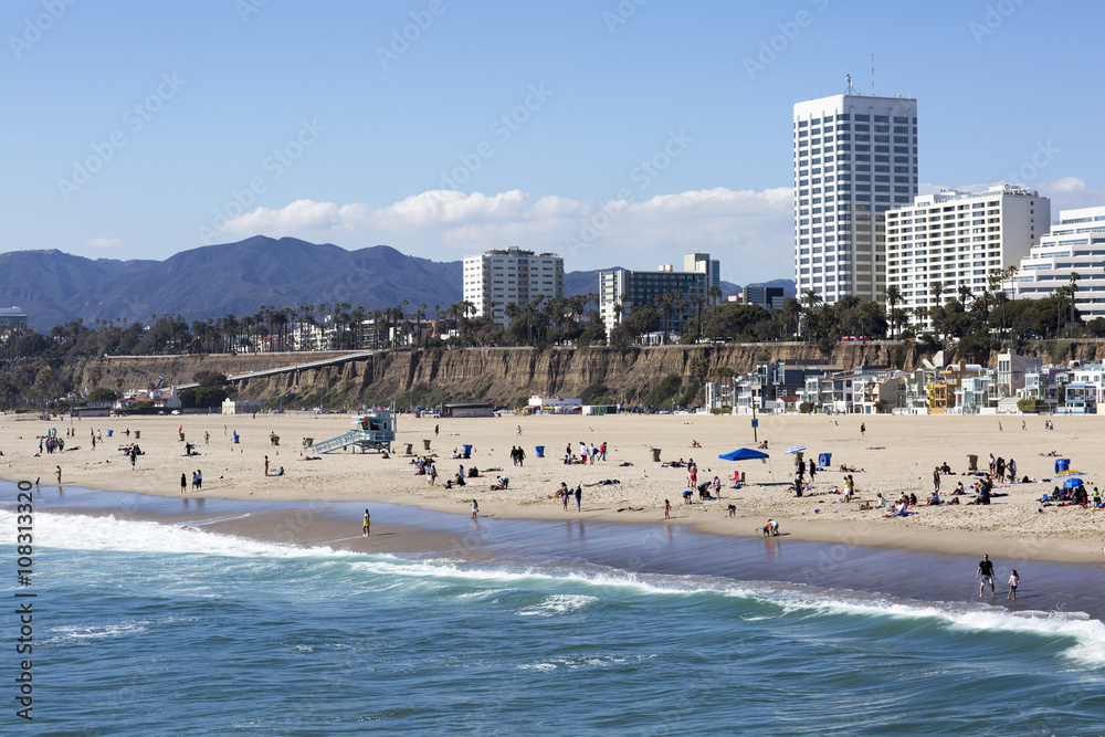 Wall mural The Pacific ocean and a clear day, Santa Monica. Beach landscape in the USA with blue sea and mountain ranges. People relax on the beach. 