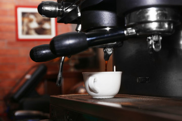 Fresh coffee making in the professional coffee machine, close up