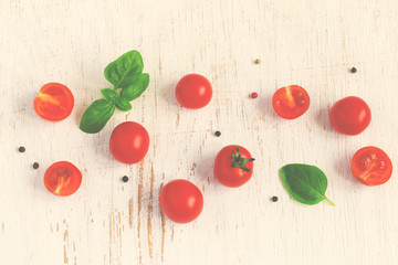 Cherry tomatoes with basil leaves on white Shabby background, ti