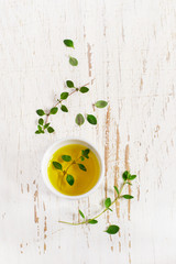 Sprigs of thyme and olive oil on a white Shabby background, top