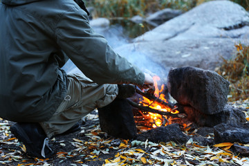 Man making fire in mountains