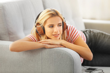 Young woman on a sofa listening to music