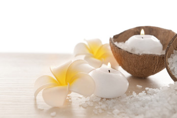 Fototapeta na wymiar Spa concept of plumeria, coconut and candles with sea salt, isolated on white