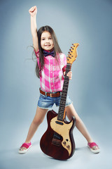 Fototapeta premium Beautiful artistic little girl playing guitar on grey background