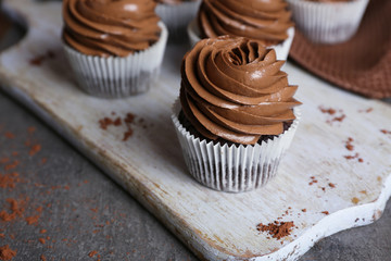 Chocolate cupcakes on a tray over grey background, close up