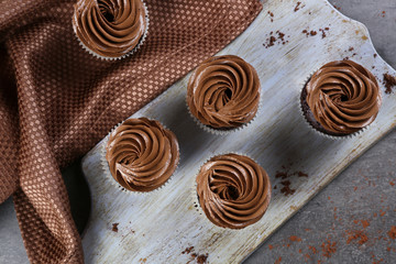 Chocolate cupcakes on a tray over grey background