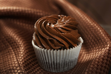 Chocolate cupcake on cloth background, close up
