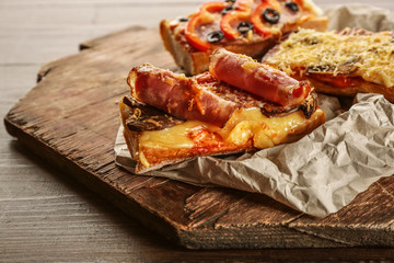 Hot pizza baguette with bacon and cheese on wooden table