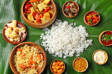 Boiled and fried rice with vegetables, spices on banana leaf, close up