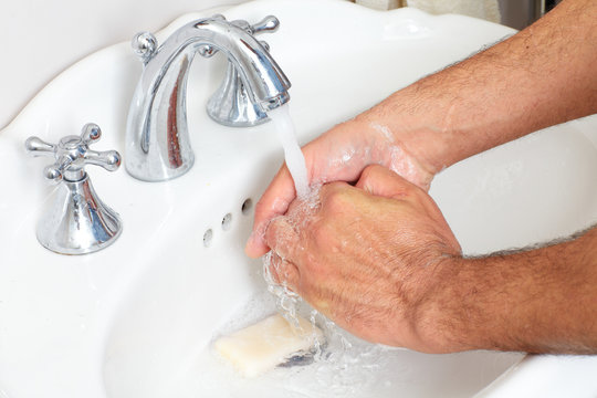 Man washing hands with soap and water.